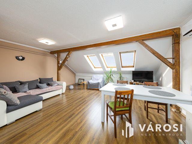 Látszó fagerendás tetőtéri lakás csendes utcában